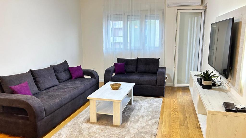 a living room with a couch and a table at Comfort Central Point apartment in Podgorica