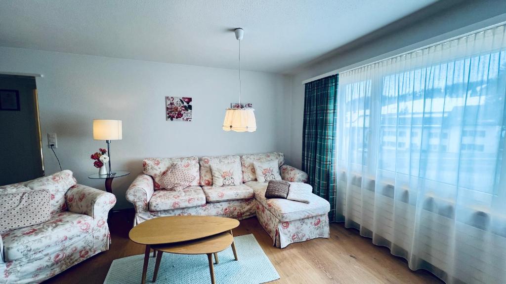 ein Wohnzimmer mit einem Sofa und einem Tisch in der Unterkunft Casa Terza - CharmingStay in Flumserberg