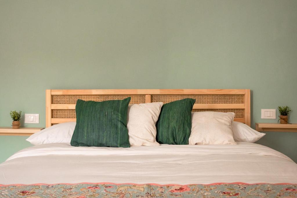 a bedroom with a bed with green pillows at Villa Gelsomino in Modica