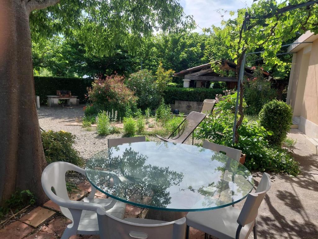 a glass table and chairs on a patio at Charmante maison avec jardin in Manosque