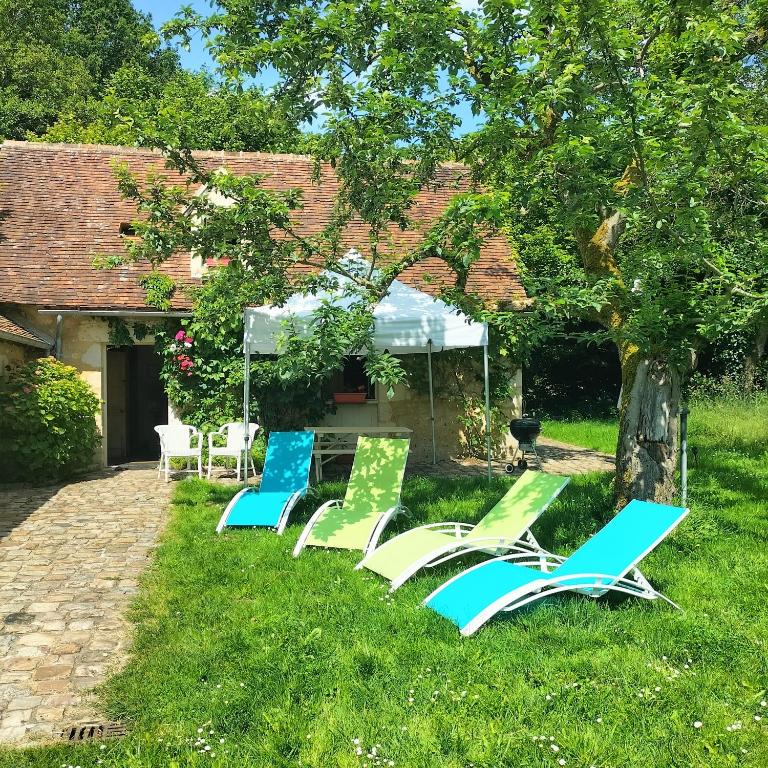 a group of lawn chairs sitting in the grass at Séjour au Moulin de Boiscorde, Le Perche in Rémalard
