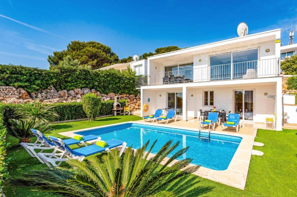 een villa met een zwembad en een tuin bij Villa Grace by Villa Plus in Es Mercadal