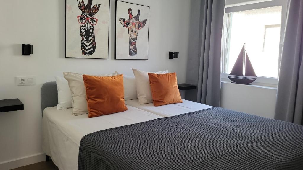 ein Schlafzimmer mit einem Bett mit zwei Giraffengemälden an der Wand in der Unterkunft La Esquina in Denia