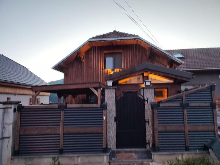 une maison en bois avec une porte en face dans l'établissement Green Valley, à Habère-Lullin