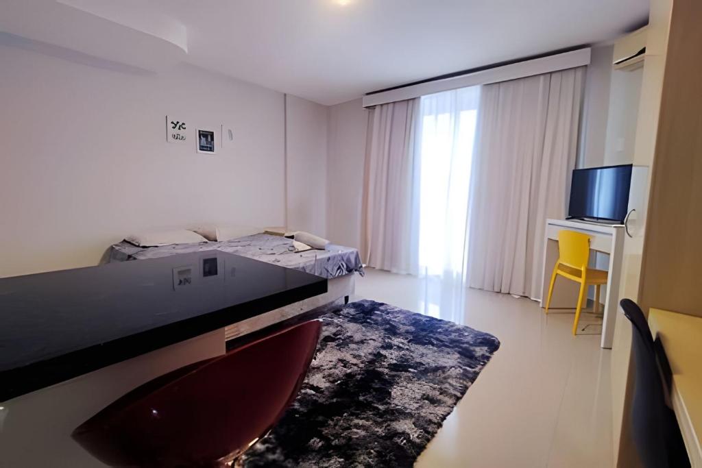 Habitación blanca con cama y TV en Saint Sebastian ap103-stúdio PNE, en Jaraguá do Sul