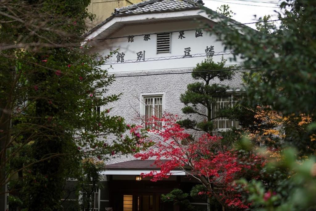 Casa blanca con ventana roja y árboles en Hazu Bekkan en Ono