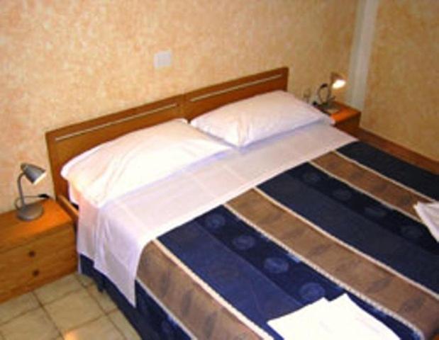 Hotel Bolognese في فولينيو: غرفة نوم بسرير كبير مع وسادتين