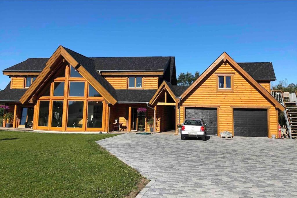 a house with a car parked in front of it at Bjælkehuset in Løkken