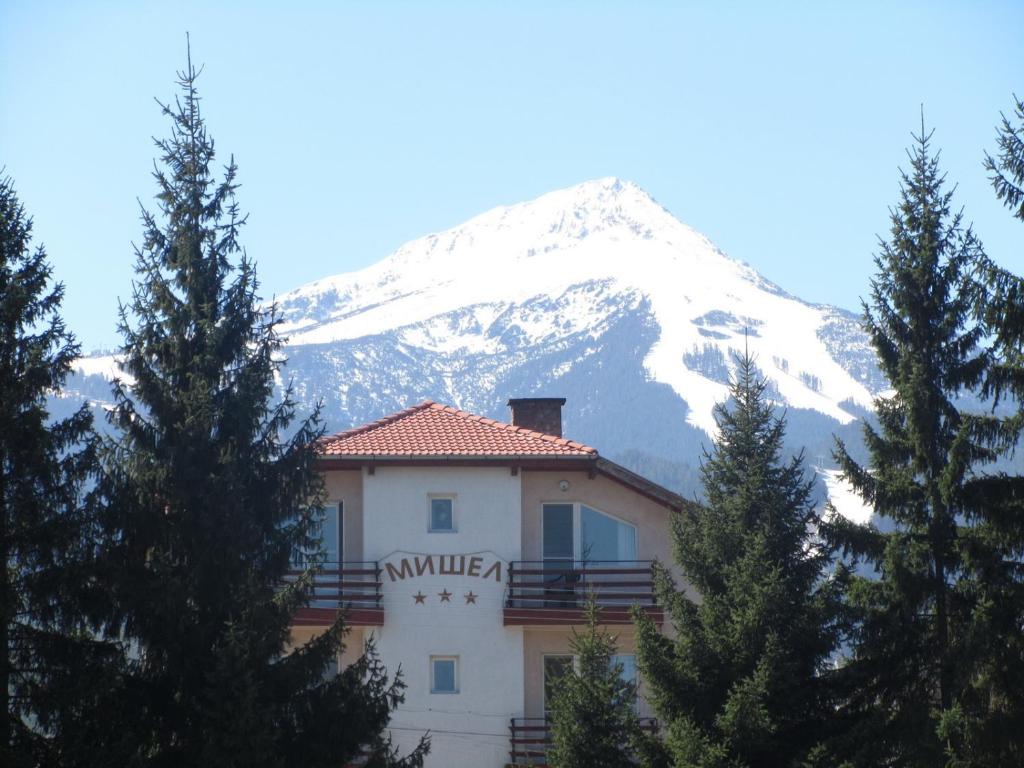 a building in front of a snow covered mountain at Michel Hotel in Bansko