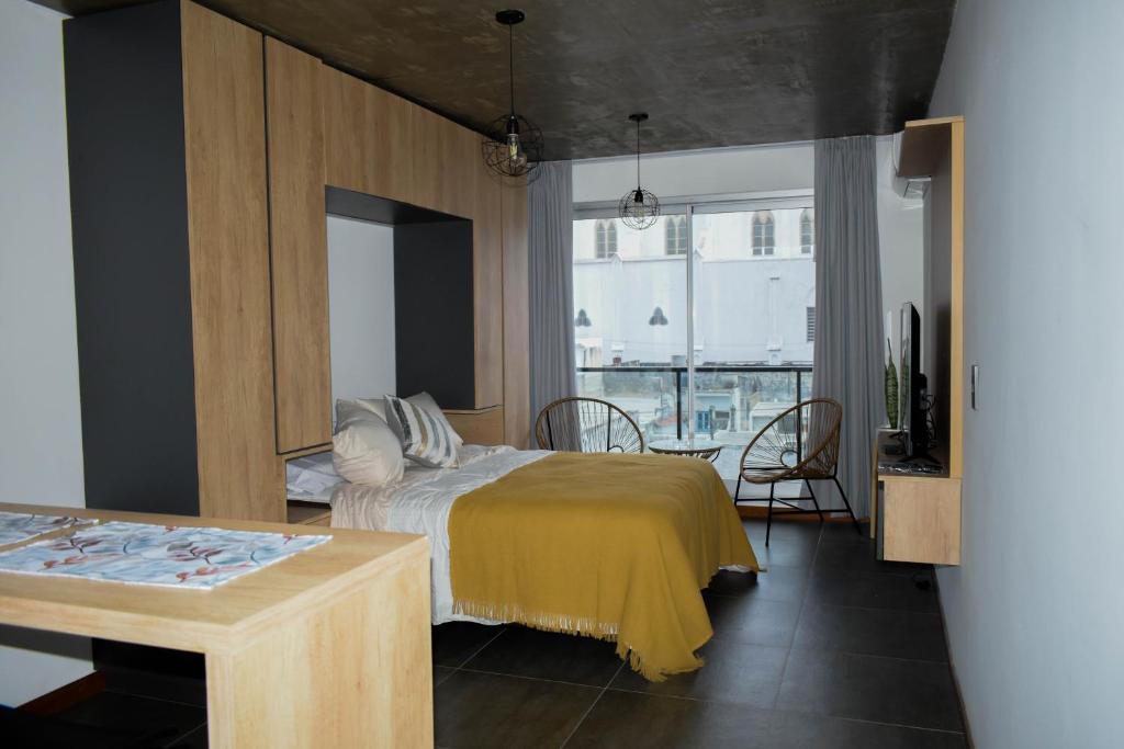 1 dormitorio con 1 cama con manta amarilla en Home Rosario, en Rosario