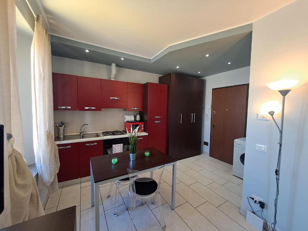 a kitchen with red cabinets and a table with chairs at Appartamento Valentina in Cremona