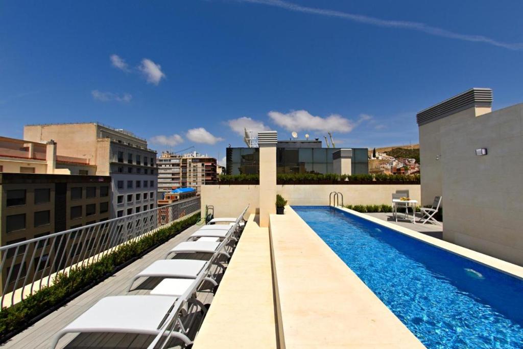 a swimming pool on the roof of a building at Hostal Rambla 24 by Holihome in Alicante