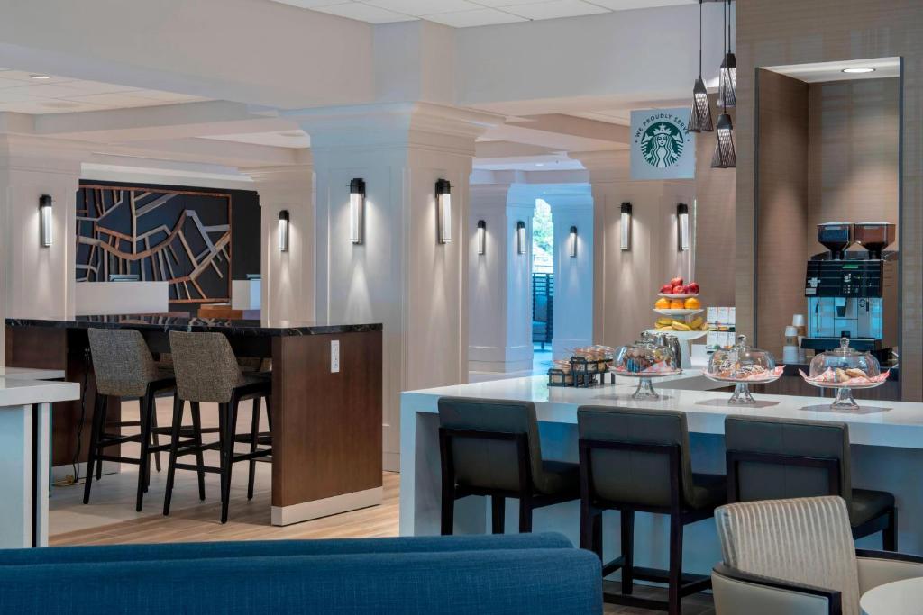 a kitchen and dining room with a bar with chairs at Boston Marriott Peabody in Peabody