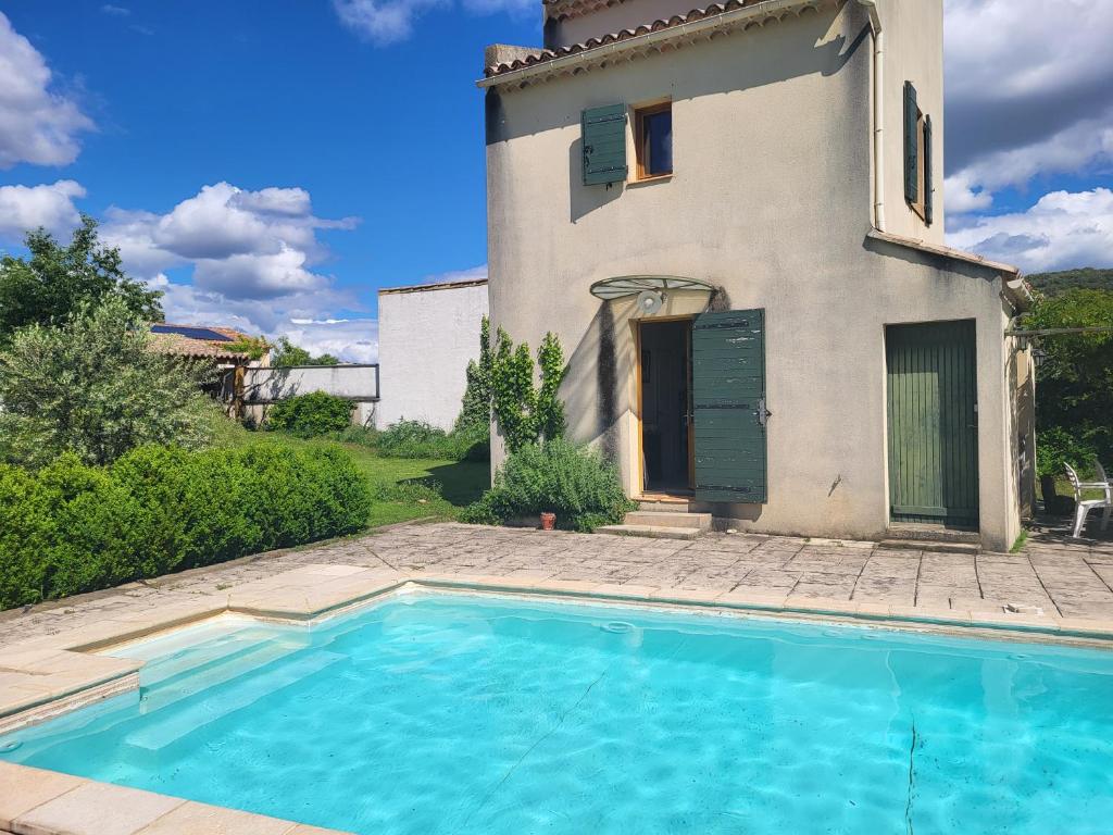 une villa avec piscine devant un immeuble dans l'établissement Villa vue sur la Garrigue avec piscine, à Valliguières