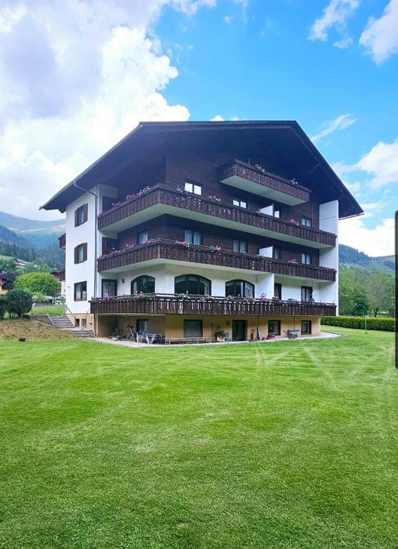 duży budynek z zielonym polem przed nim w obiekcie Apartments Edenhof w mieście Bad Kleinkirchheim