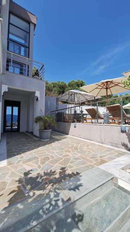 a house with a patio with a view of the ocean at Sarti Thea in Sarti