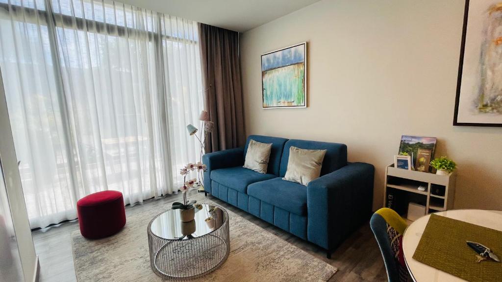 Cozy apartment with terrace, SJ Cosmopolitan Tower في سان خوسيه: غرفة معيشة مع أريكة زرقاء وطاولة