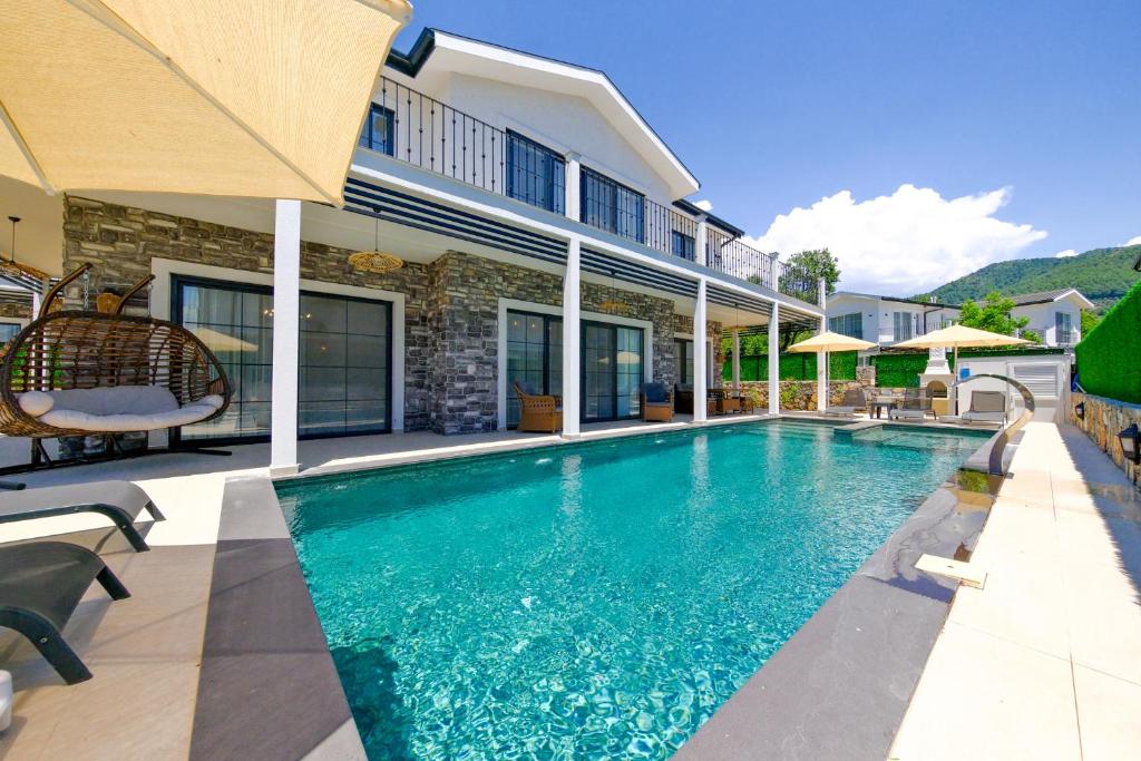 a swimming pool in the backyard of a house at Lily of the Valley Luxury Villa Fethiye, Yesiluzumlu by Sunworld Villas in Fethiye