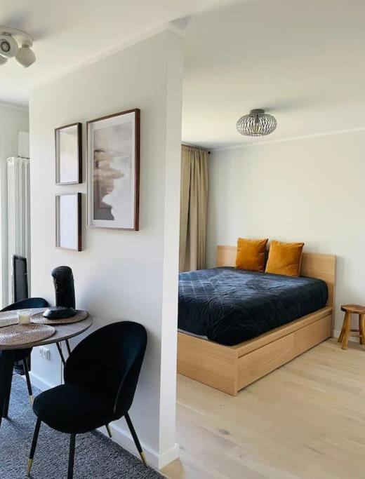 a bedroom with a bed and a table and chairs at Apartment by seaside in Ķesterciems