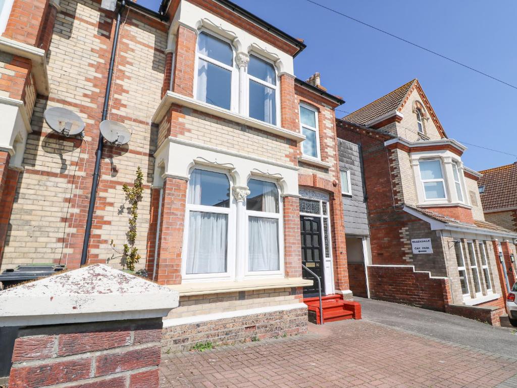ein Backsteinhaus mit einem großen Fenster auf einer Straße in der Unterkunft Gone Fishing in Weymouth