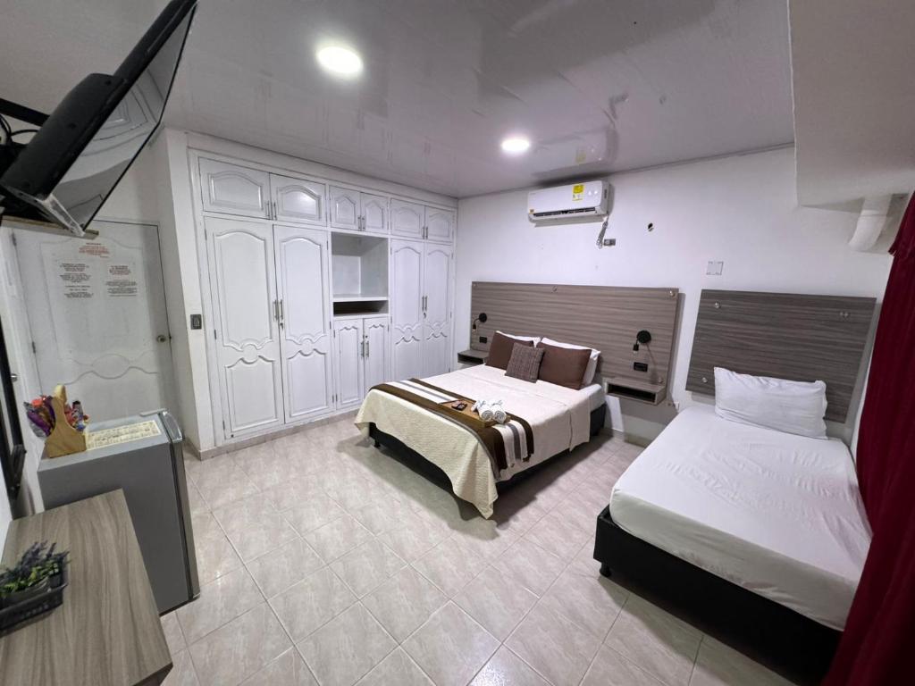 ein Hotelzimmer mit 2 Betten und einer Küche in der Unterkunft Hotel la Sierra Riohacha II in Ríohacha