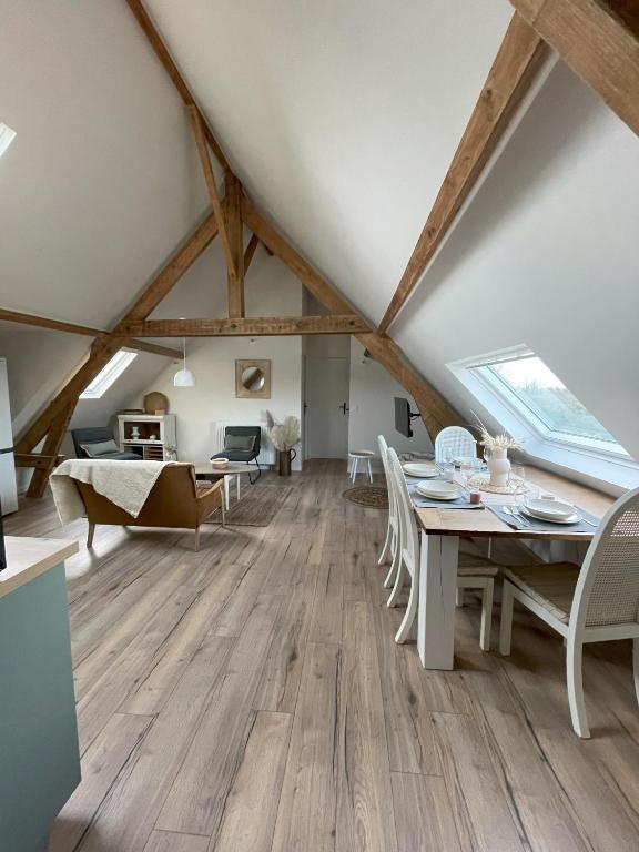 - une salle à manger mansardée avec une table et des chaises dans l'établissement le gite de la pommeraie, à Le Bois-Robert