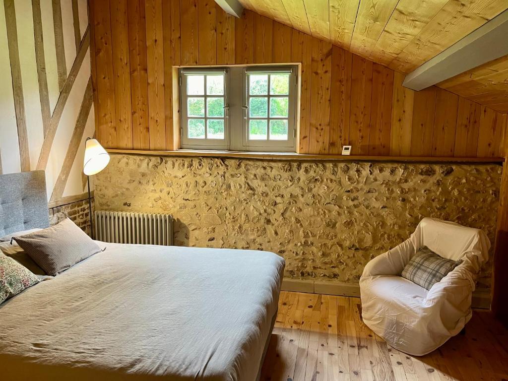 a bedroom with a bed and a couch and a window at Paisible cottage au bord de l'eau -15 mn des côtes in Pierrefitte-en-Auge