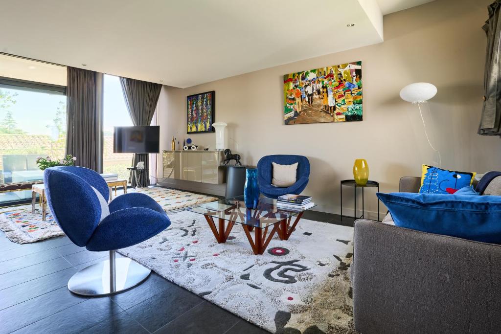 un salon avec des chaises bleues et un canapé dans l'établissement Sérénité au fil de l'eau Appartement de standing, à LʼIsle-sur-la-Sorgue