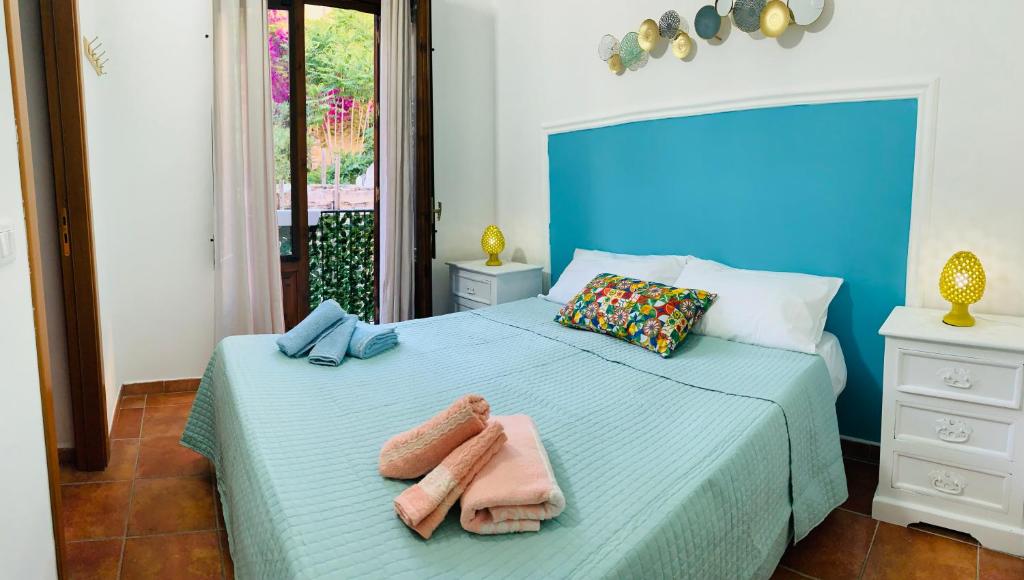 a blue bedroom with two towels on a bed at Cathedral House in Palermo