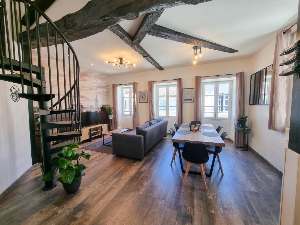 una sala de estar con una mesa y un sofá en Duplex Le Chai de l'Abreuvoir, en Saintes