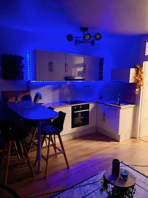 une cuisine bleue avec une table et des chaises dans l'établissement Appart F2 40m2 Stade de France, à Saint-Denis