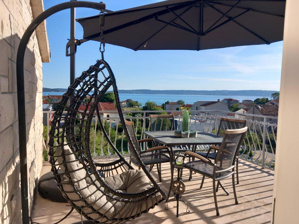 a patio with a table and chairs and an umbrella at Barun apartments Kastela in Kaštela