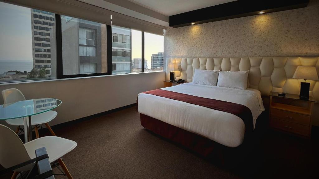 ein Hotelzimmer mit einem großen Bett und einem Fenster in der Unterkunft Hotel Ferré Miraflores in Lima