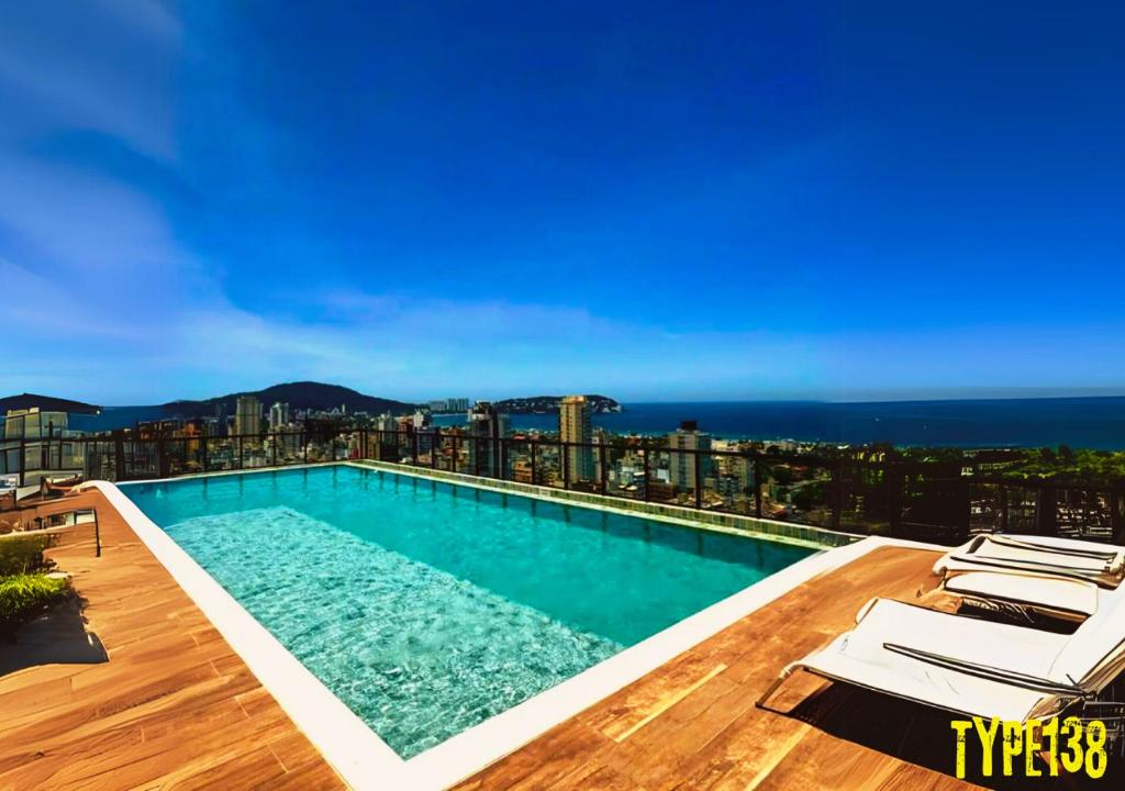 Apto Incrível - Piscina no Rooftop - Vista Mar - 600m Praia Enseada في غوارويا: حمام سباحة على سطح مبنى