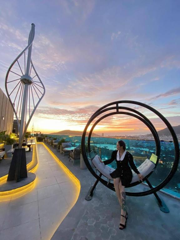 a woman is sitting in a circular chair on a roof at Nice apartment in Vung Tau WE WELCOME YOU! in Vung Tau