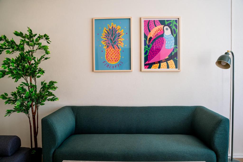 sala de estar con sofá verde y 2 fotografías en Pietarsaaren Helmi, en Jakobstad
