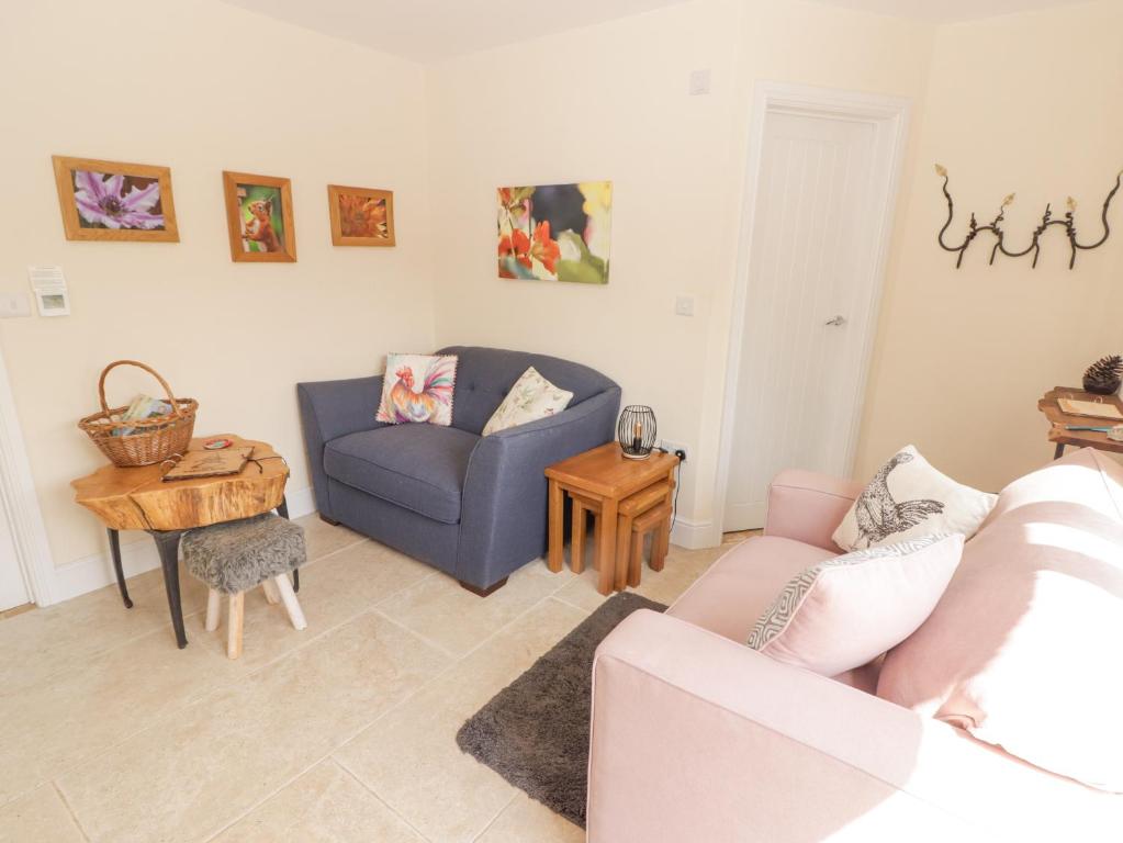 ein Wohnzimmer mit einem blauen Sofa und einem Tisch in der Unterkunft Yemble Rose in Cardigan