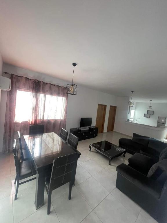 a living room with a table and a couch at Residence bellevue in Menzel Jemil