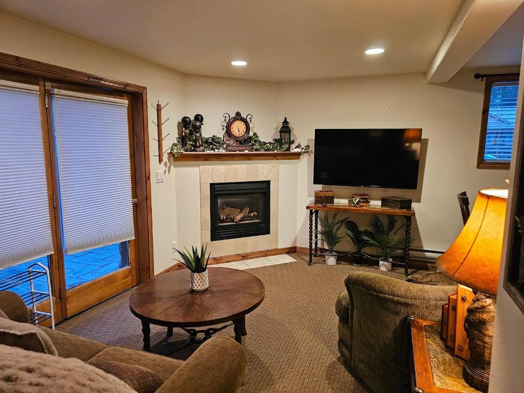 a living room with a fireplace and a tv at Alpenglow One Bedroom One Bath – A09 in Ouray