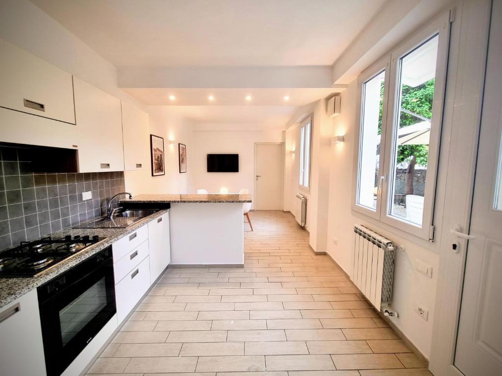 a kitchen with white cabinets and a large window at Sanremo Suite Apartment in Sanremo