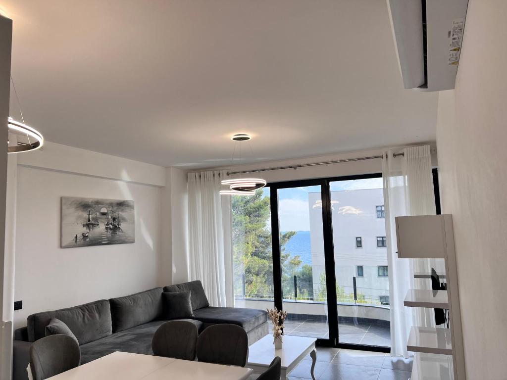 a living room with a couch and a large window at Sonely Apartament Shengjin in Shëngjin