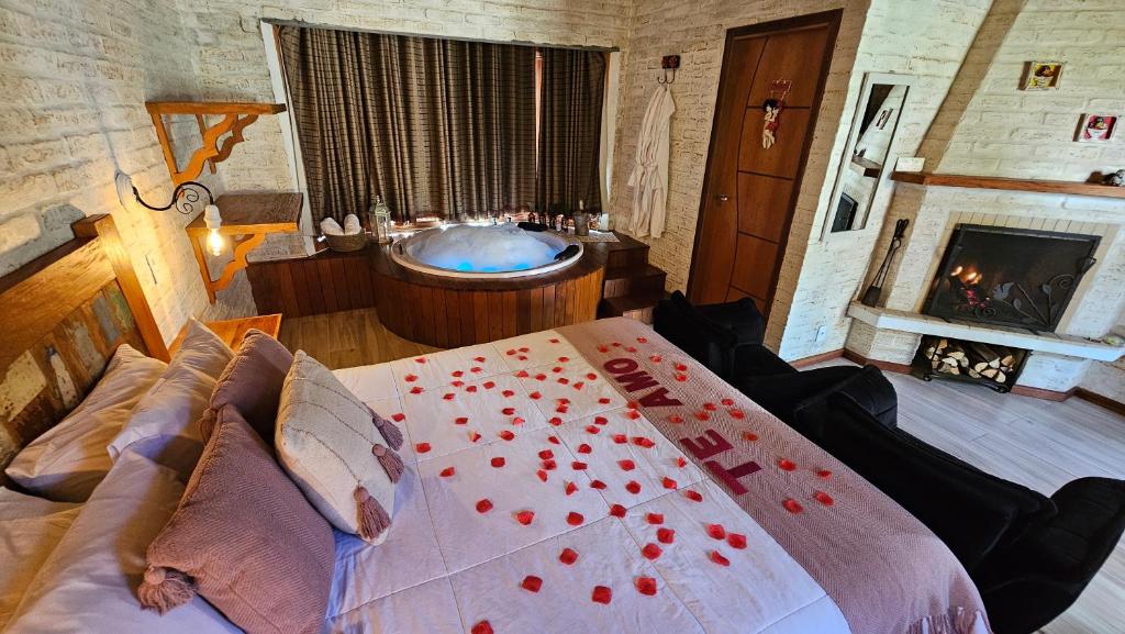 um quarto com uma cama e uma banheira em Chalé Gosto da Roça em Monte Verde