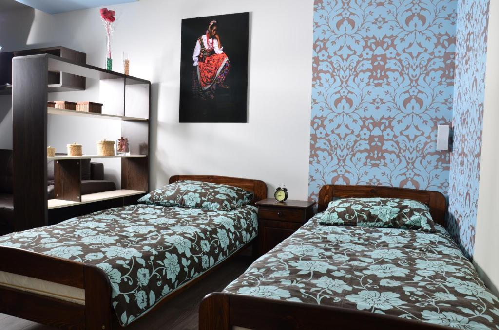 キェルツェにあるApartament Kielce Folkの青と白の壁紙を用いた客室内のベッド2台