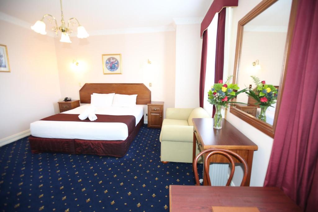カトゥーンバにあるパレ ロワイヤルのベッドとテーブルが備わるホテルルームです。