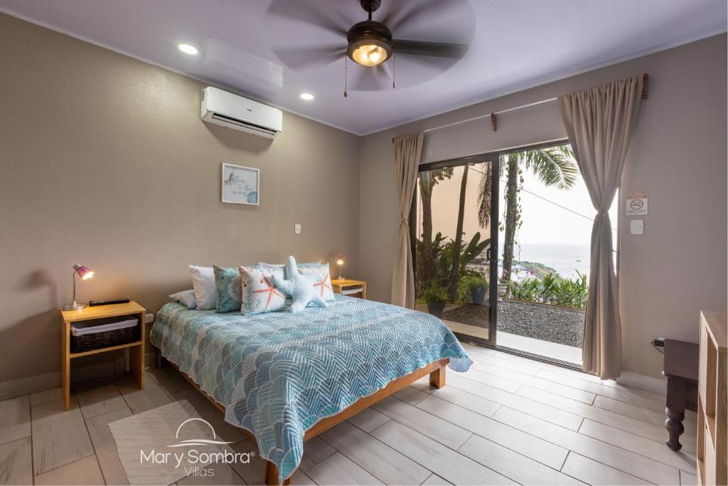 奎波斯城的住宿－Mar y Sombra Villas，一间卧室配有一张床和吊扇
