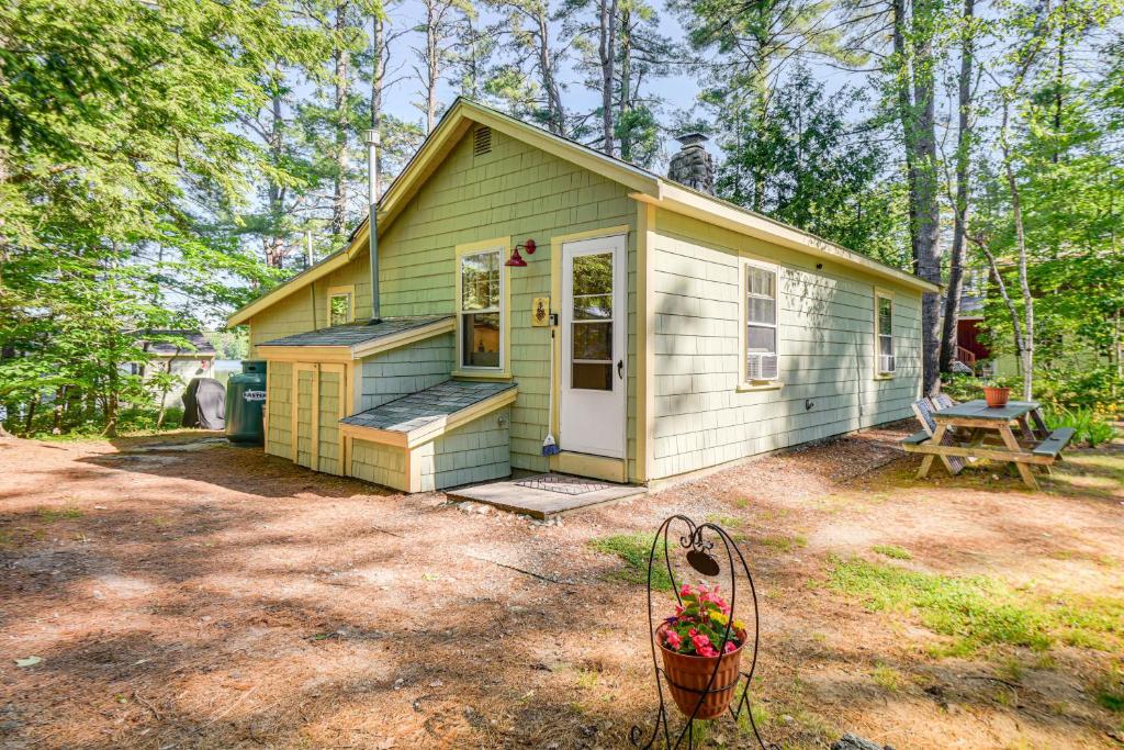 a small green house with a picnic table in front of it at Pet-Friendly Waterfront Cottage On-Site Bunkhouse in East Wakefield