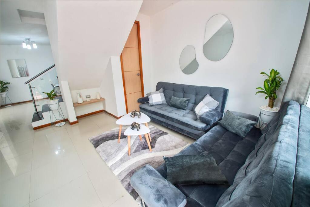 Una sala de estar con un sofá azul y una mesa. en Casa Hotel Bewell - Los colores Medellín, en Medellín