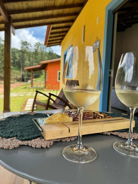 two glasses of white wine sitting on a table at Sítio Koi in Domingos Martins