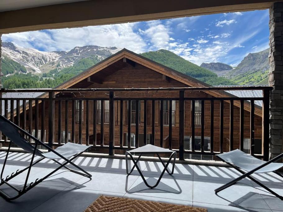un balcon avec des chaises et une vue sur les montagnes dans l'établissement Mont d'Auron - 3p- résidence neuve, à Auron