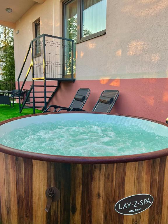 a large circular pool with chairs in front of a house at Apartment Lux Lucis in Livno